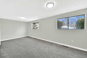 Unfurnished room with dark carpet and a textured ceiling