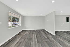 Spare room with dark wood-style flooring, electric panel, and recessed lighting