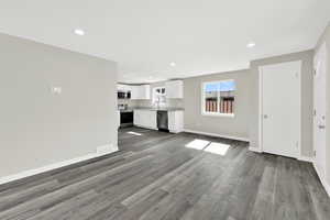 Unfurnished living room with recessed lighting and dark wood-style flooring