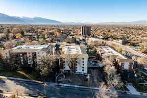 Drone / aerial view of a mountainous background and apartment complex / building