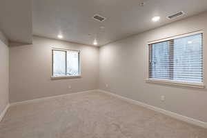Carpeted empty room featuring recessed lighting and a textured ceiling