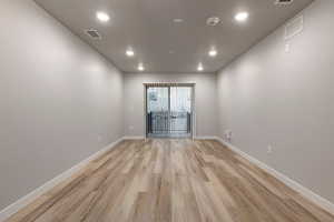 Empty room with light wood-style flooring and recessed lighting
