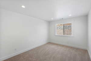 Empty room featuring light colored carpet and recessed lighting