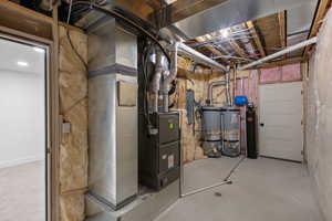 Utilities featuring gas water heater, heating unit, and electric panel