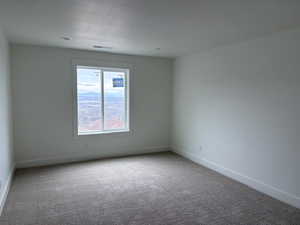 Empty room with light colored carpet and baseboards