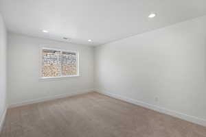Spare room featuring light carpet and recessed lighting