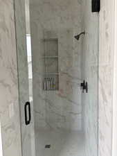 Full bathroom with a marble finish shower