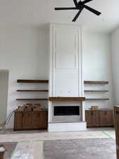 Unfurnished living room featuring a ceiling fan, a large fireplace, and recessed lighting