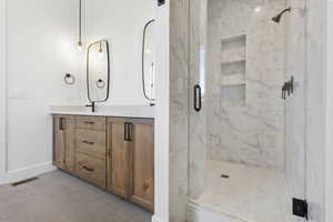 Bathroom with double vanity, a marble finish shower, and light tile patterned flooring