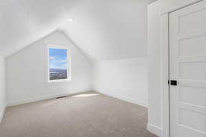 Bonus room with baseboards and carpet flooring