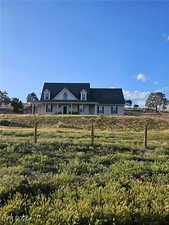 View of front of home with covered porch and a front lawn