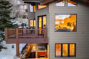 Snow covered property featuring faux log siding and a wooden deck