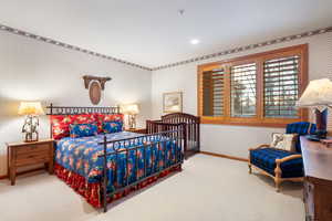 Bedroom with wallpapered walls, light colored carpet, and recessed lighting