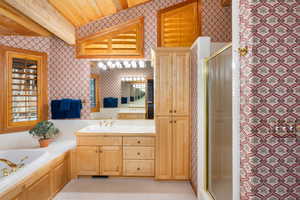 Bathroom featuring wallpapered walls, vanity, a shower stall, beamed ceiling, and a bath