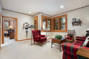 Sitting room featuring wallpapered walls, light carpet, healthy amount of natural light, and recessed lighting