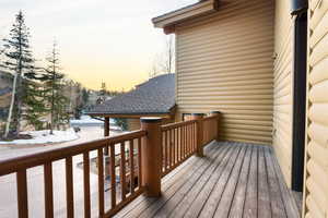 Deck at dusk featuring a balcony