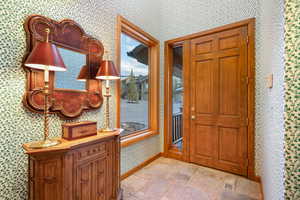 Entryway featuring stone finish floors and wallpapered walls