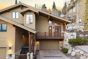 View of front of home featuring log veneer siding, a garage, and driveway
