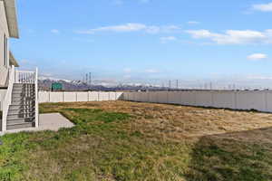 Fenced backyard featuring a mountain view and a patio