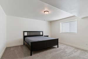 Bedroom featuring light colored carpet and a textured ceiling