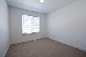 Carpeted empty room with baseboards