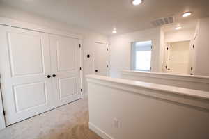 Corridor featuring light colored carpet and recessed lighting