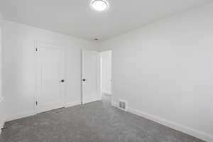 Unfurnished bedroom featuring baseboards and carpet flooring