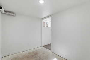 Below grade area with baseboards and a textured ceiling