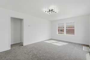Empty room featuring carpet flooring and baseboards