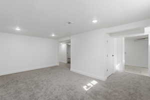 Unfurnished room featuring light colored carpet, a textured ceiling, and recessed lighting