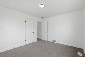 Carpeted empty room featuring baseboards