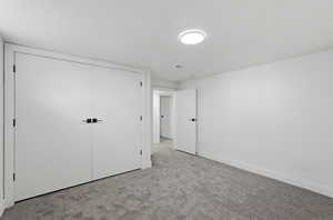 Unfurnished bedroom with a closet and light carpet