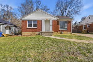 Bungalow-style home featuring a front yard and brick siding