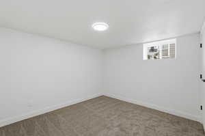Below grade area featuring baseboards and carpet