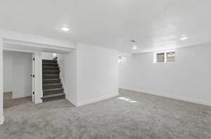 Basement featuring light colored carpet, recessed lighting, and a textured ceiling