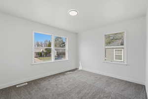 Unfurnished room with carpet floors and plenty of natural light