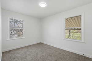 Empty room featuring carpet floors and plenty of natural light