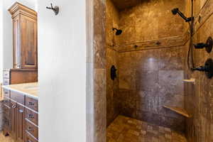 Full bath with a shower stall, vanity, and a textured wall