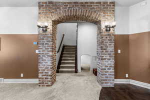 Staircase with arched walkways and carpet