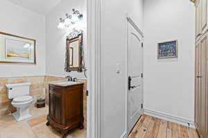 Bathroom featuring vanity, tile walls, and wainscoting