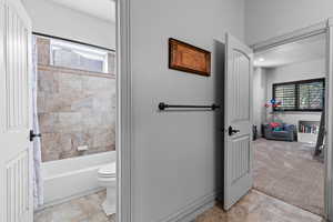 Full bathroom with plenty of natural light, shower / tub combo, and light carpet