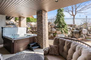 View of patio with a hot tub and an outdoor lounge area