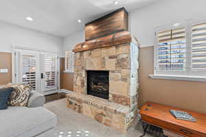 Living room featuring a fireplace, recessed lighting, and french doors
