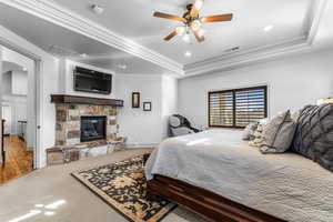 Bedroom featuring crown molding, carpet, arched walkways, ceiling fan, and a tray ceiling