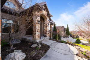 Property entrance featuring brick siding and stone siding