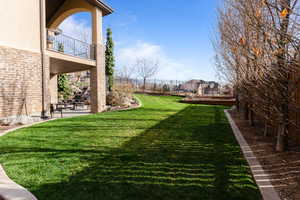 Fenced yard featuring a patio area and a balcony
