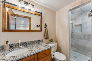 Full bathroom featuring vanity, a shower stall, and a textured ceiling