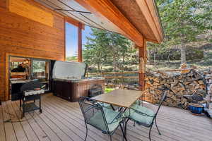 Wooden deck featuring outdoor dining area and a hot tub