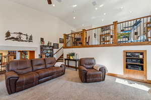 Carpeted living area featuring recessed lighting, a ceiling fan, and vaulted ceiling