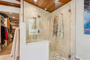 Bathroom with a spacious closet, a stall shower, vaulted ceiling, and recessed lighting